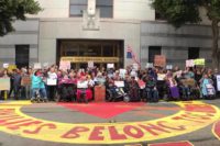 A large crowd of disabled, fat and elder protesters in front of the ICE building in San Francisco. Photo by Leslie Mah